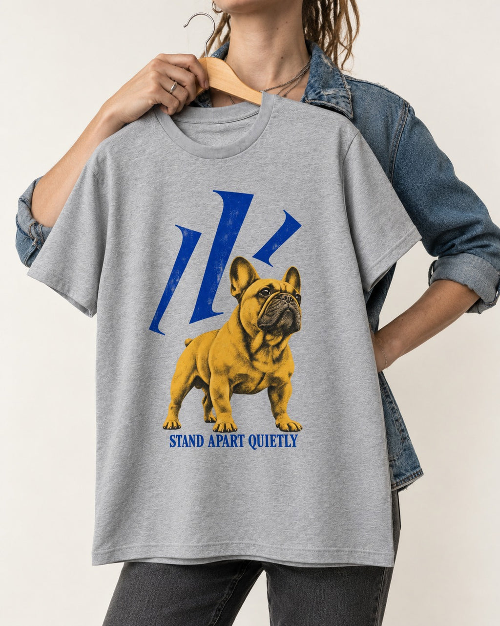 Frenchie Stand Apart Quietly T-Shirt in Sport Grey, held up on a hanger