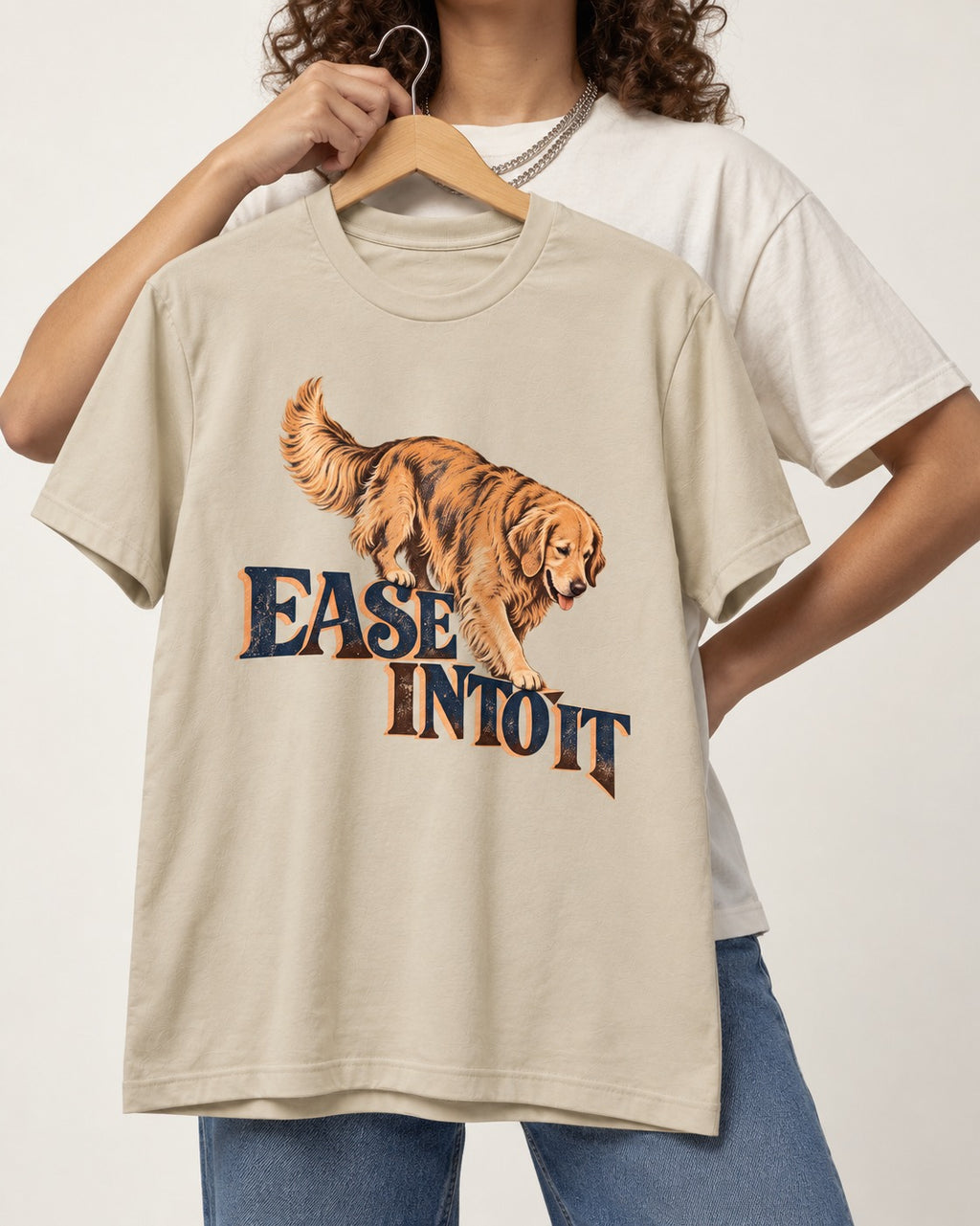 Golden Retriever Ease Into It T-Shirt in Sand, held up on a hanger