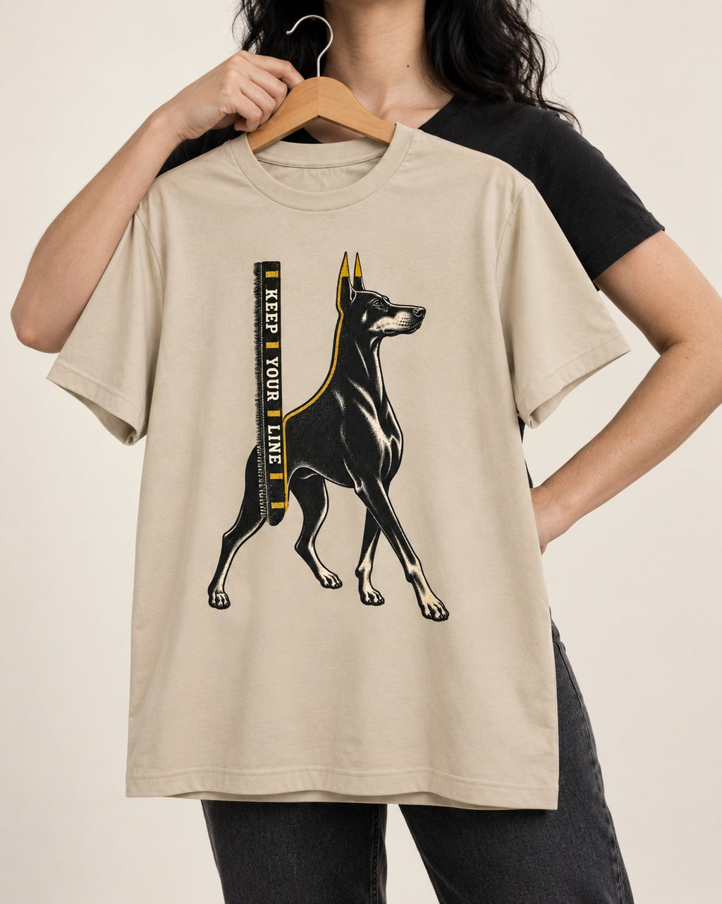 Keep Your Line Doberman T-Shirt in Sand, held up on a hanger