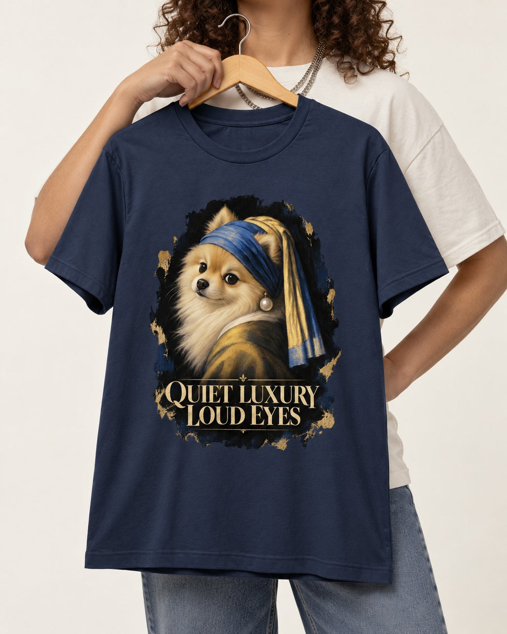 Pomeranian Quiet Luxury Loud Eyes Pearl Portrait Graphic T-Shirt in Navy, held up on a hanger
