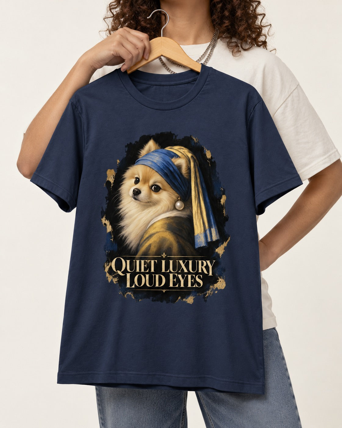 Pomeranian Quiet Luxury Loud Eyes Pearl Portrait Graphic T-Shirt in Navy, held up on a hanger