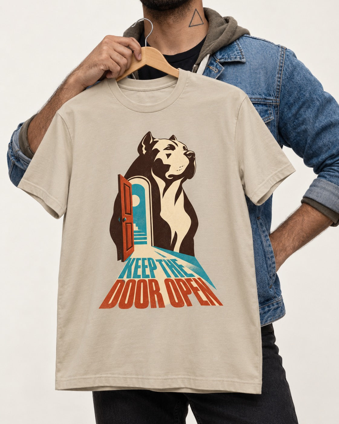 Keep the Door Open Pitbull T-Shirt in Sand, held up on a hanger
