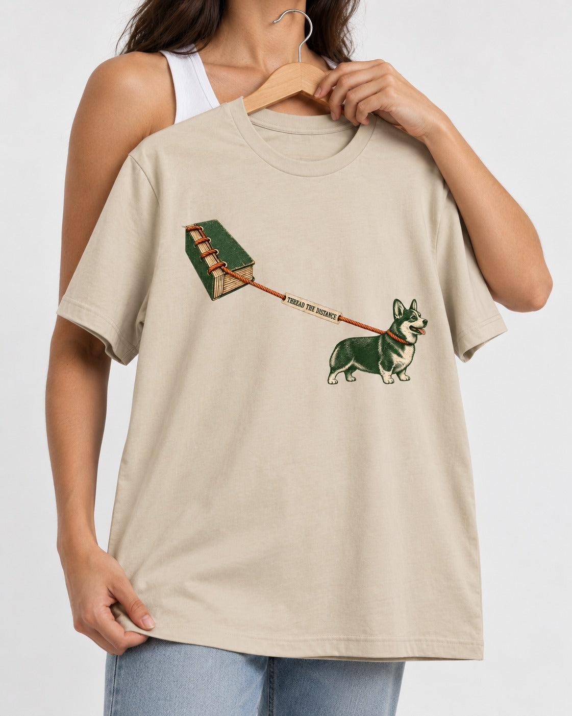 Thread the Distance with Corgi T-Shirt in Sand, held up on a hanger