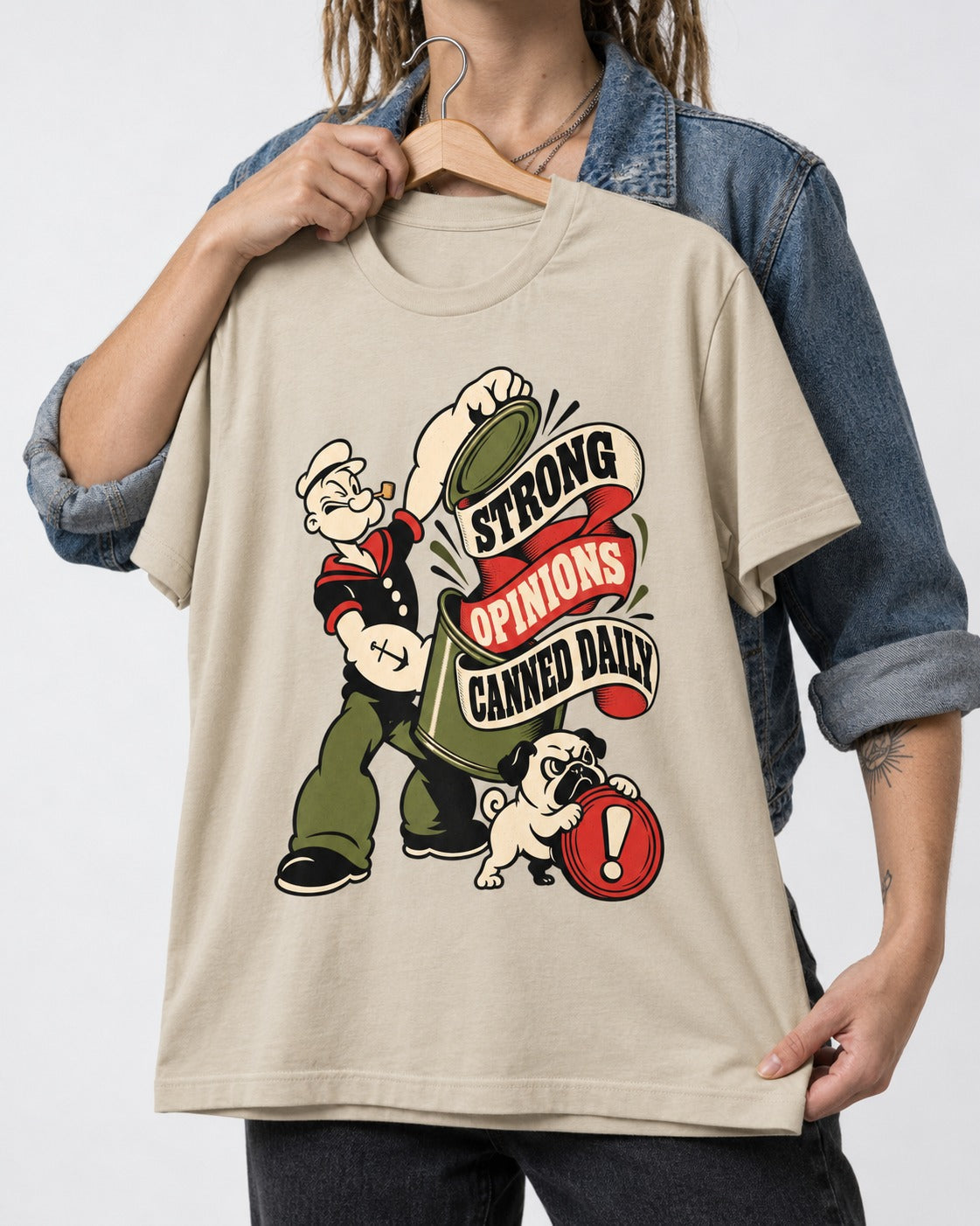 Pug Strong Opinions T-Shirt in Sand, held up on a hanger