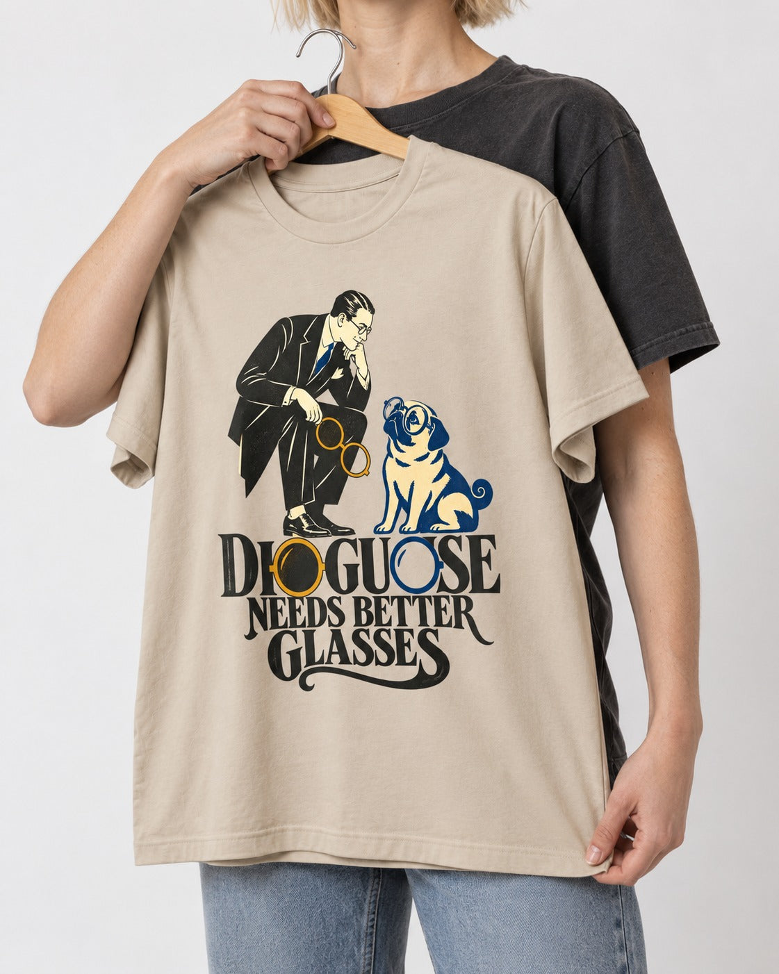 Pug Needs Better Glasses T-Shirt in Sand, held up on a hanger