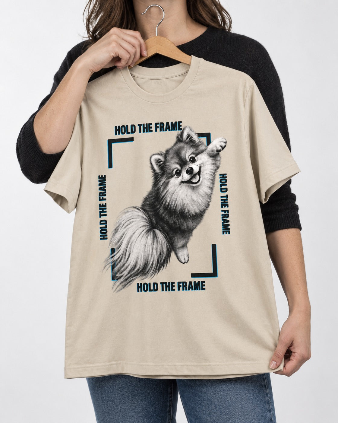 Hold the Frame Pomeranian T-Shirt in Sand, held up on a hanger