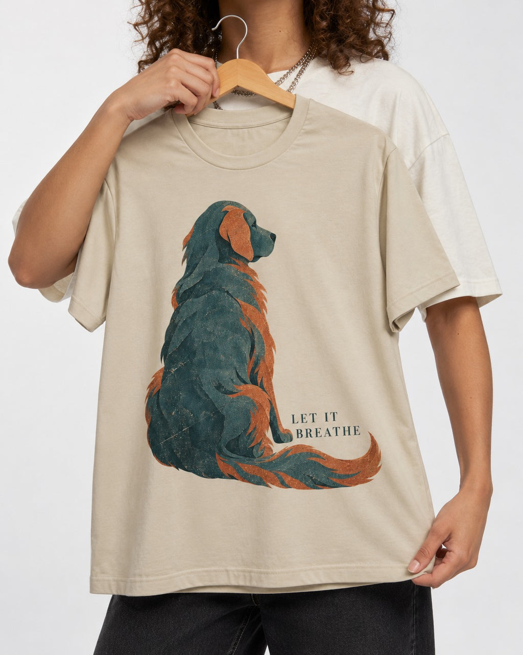 Let It Breathe Golden Retriever T-Shirt in Sand, held up on a hanger