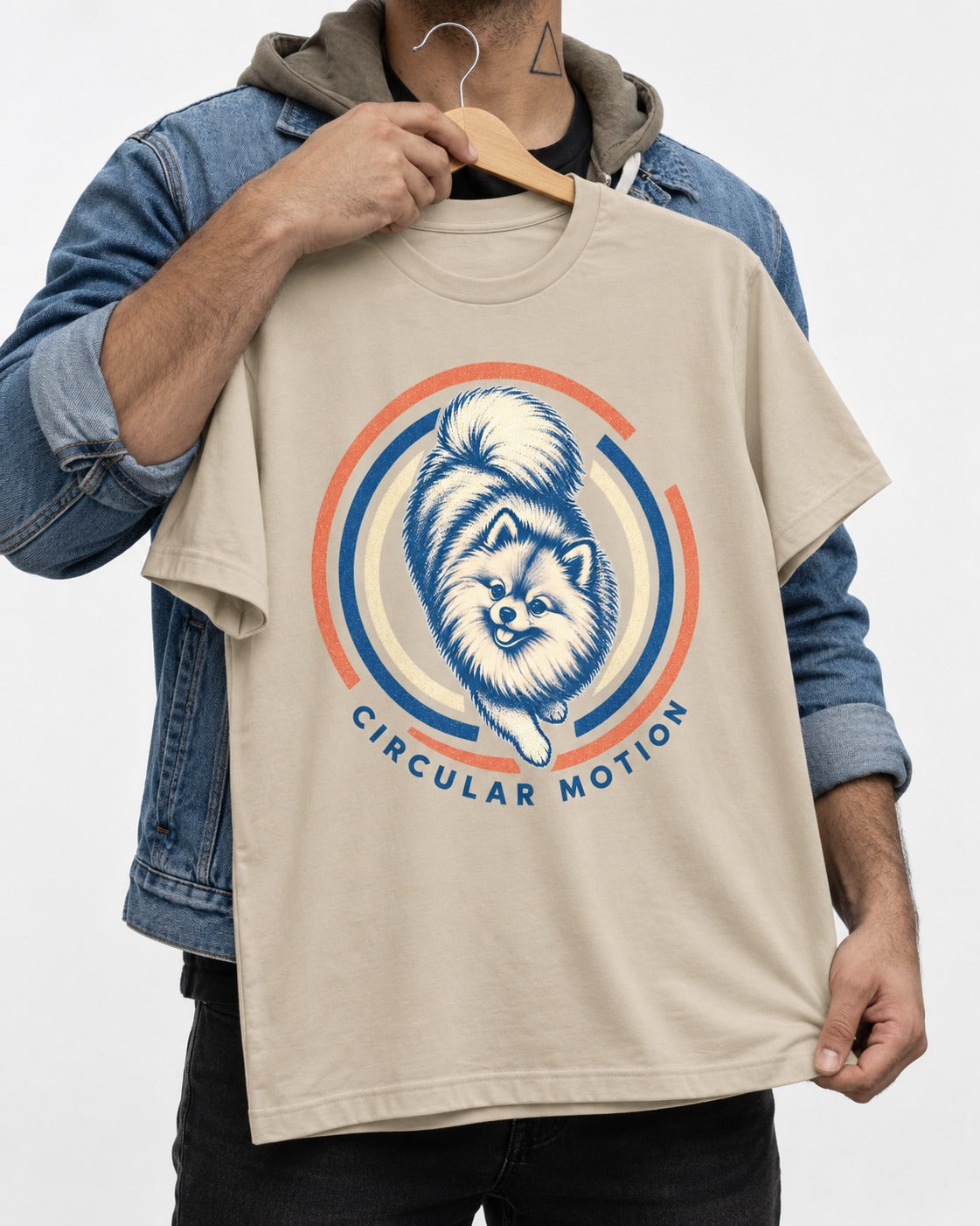 Pomeranian Circular Motion T-Shirt in Sand, held up on a hanger