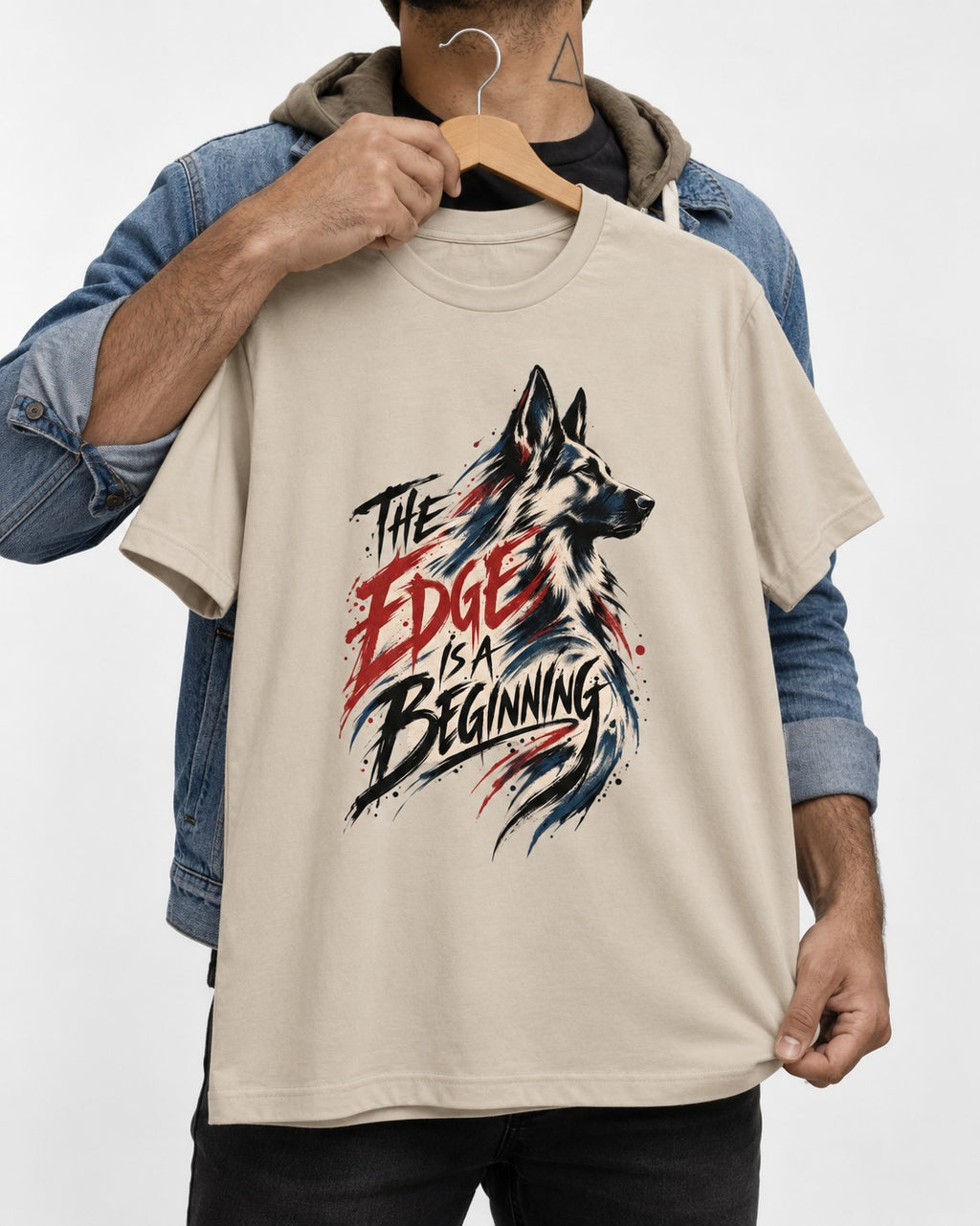 Edge Is a Beginning German Shepherd Dog T-Shirt in Sand, held up on a hanger
