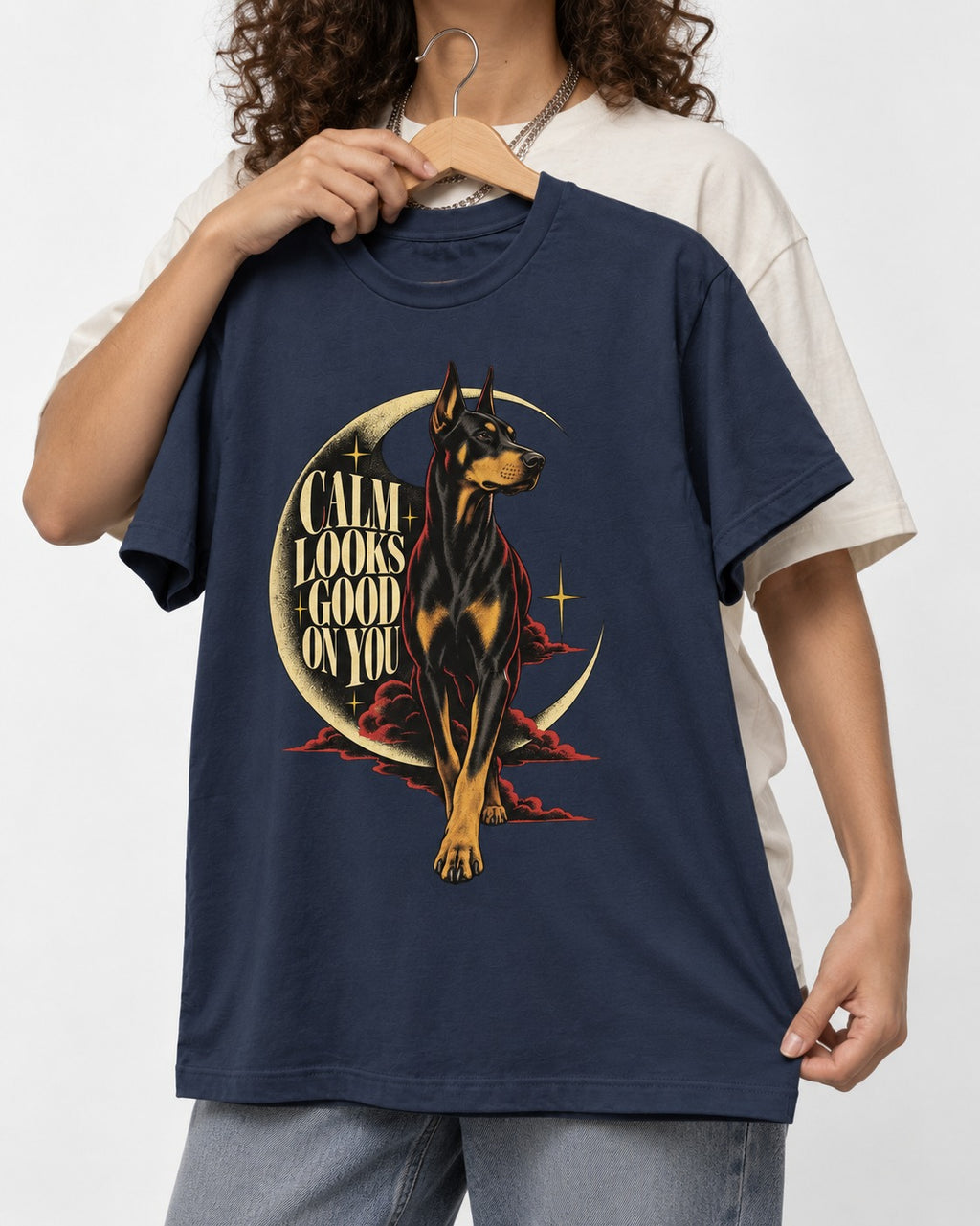 Doberman Calm Looks Good on You Crescent Graphic T-Shirt in Navy, held up on a hanger