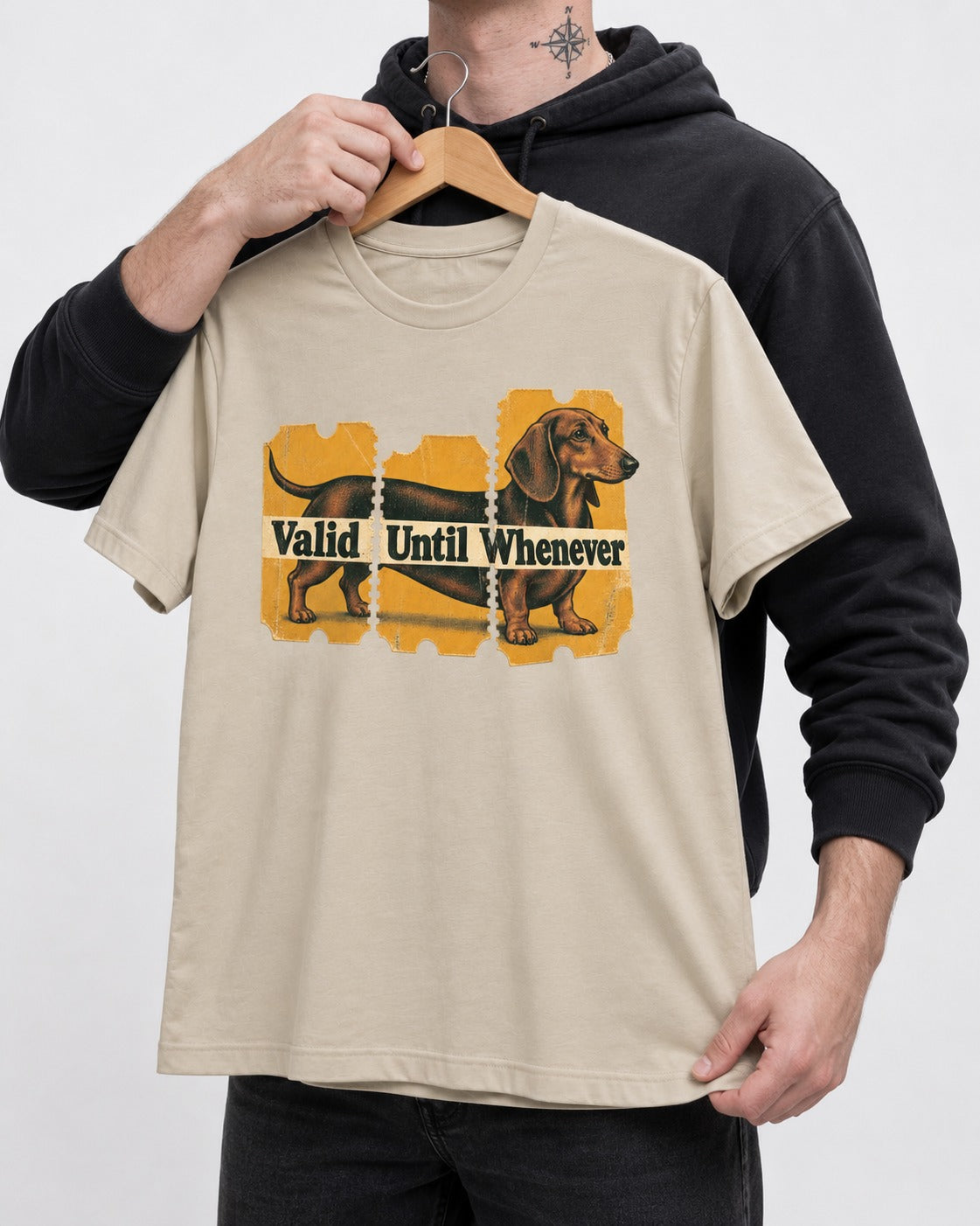Dachshund Valid Until Whenever T-Shirt in Sand, held up on a hanger