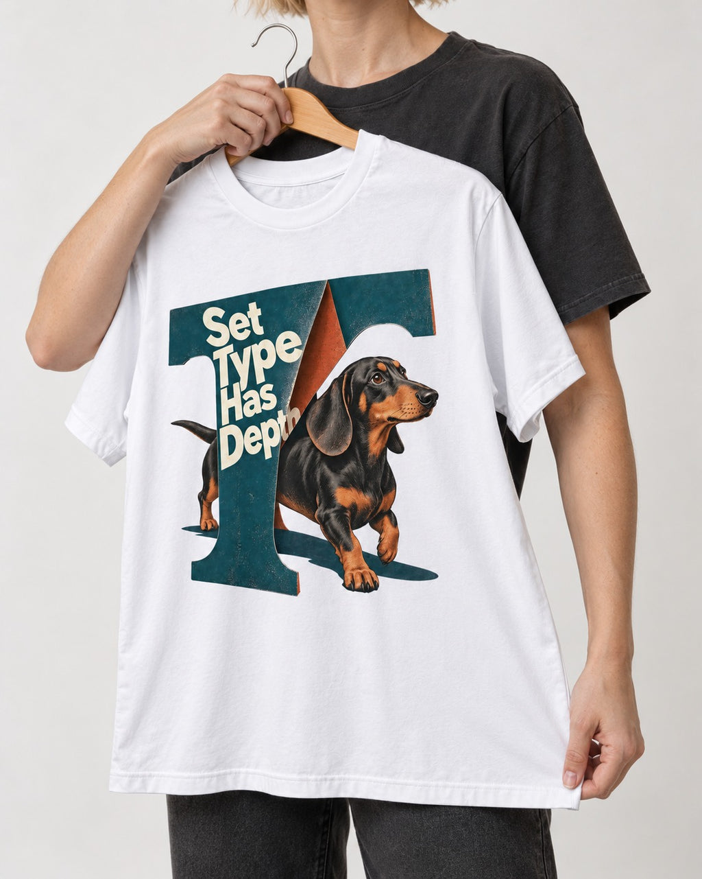Dachshund Set Type Has Depth Folded Letter Graphic T-Shirt in White, held up on a hanger