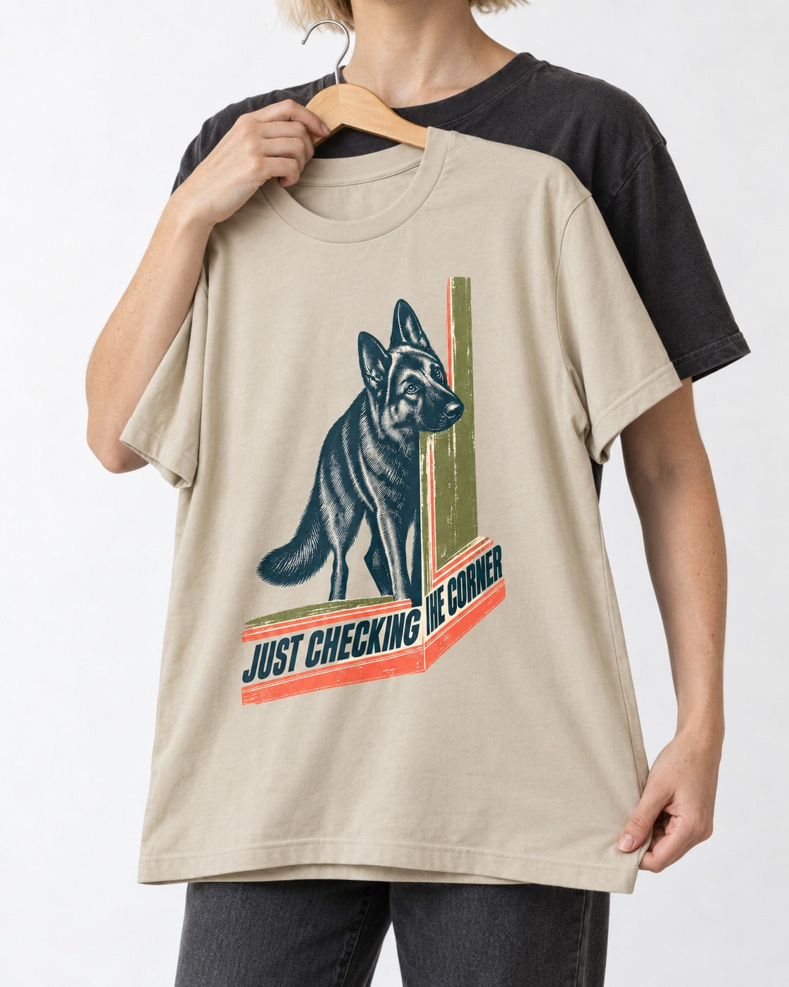 German Shepherd Dog Just Checking the Corner T-Shirt in Sand, held up on a hanger