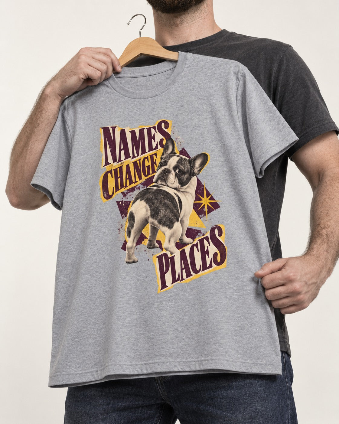 Frenchie Names Change Places Purple Poster Graphic T-Shirt in Sport Grey, held up on a hanger