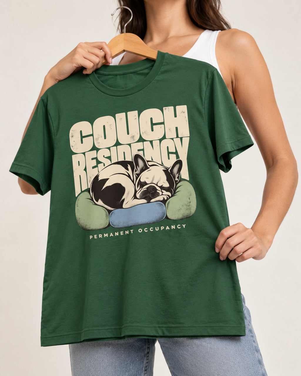 Frenchie Couch Residency Permanent Occupancy Cushion Graphic T-Shirt in Forest Green, held up on a hanger