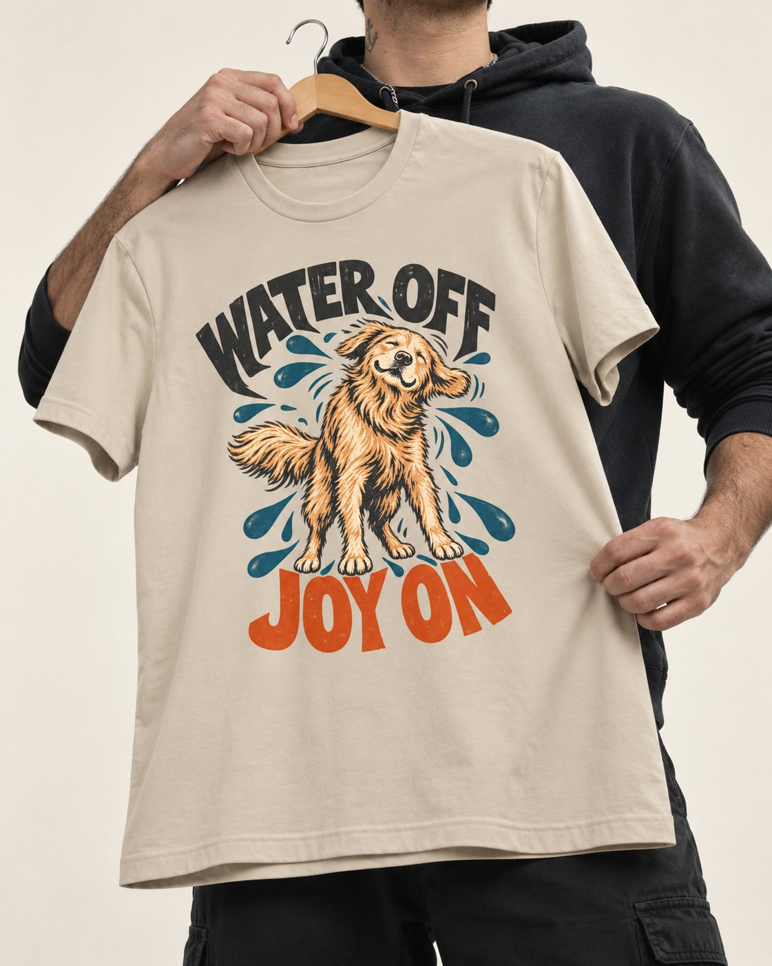Water Off Joy on Golden Retriever T-Shirt in Sand, held up on a hanger
