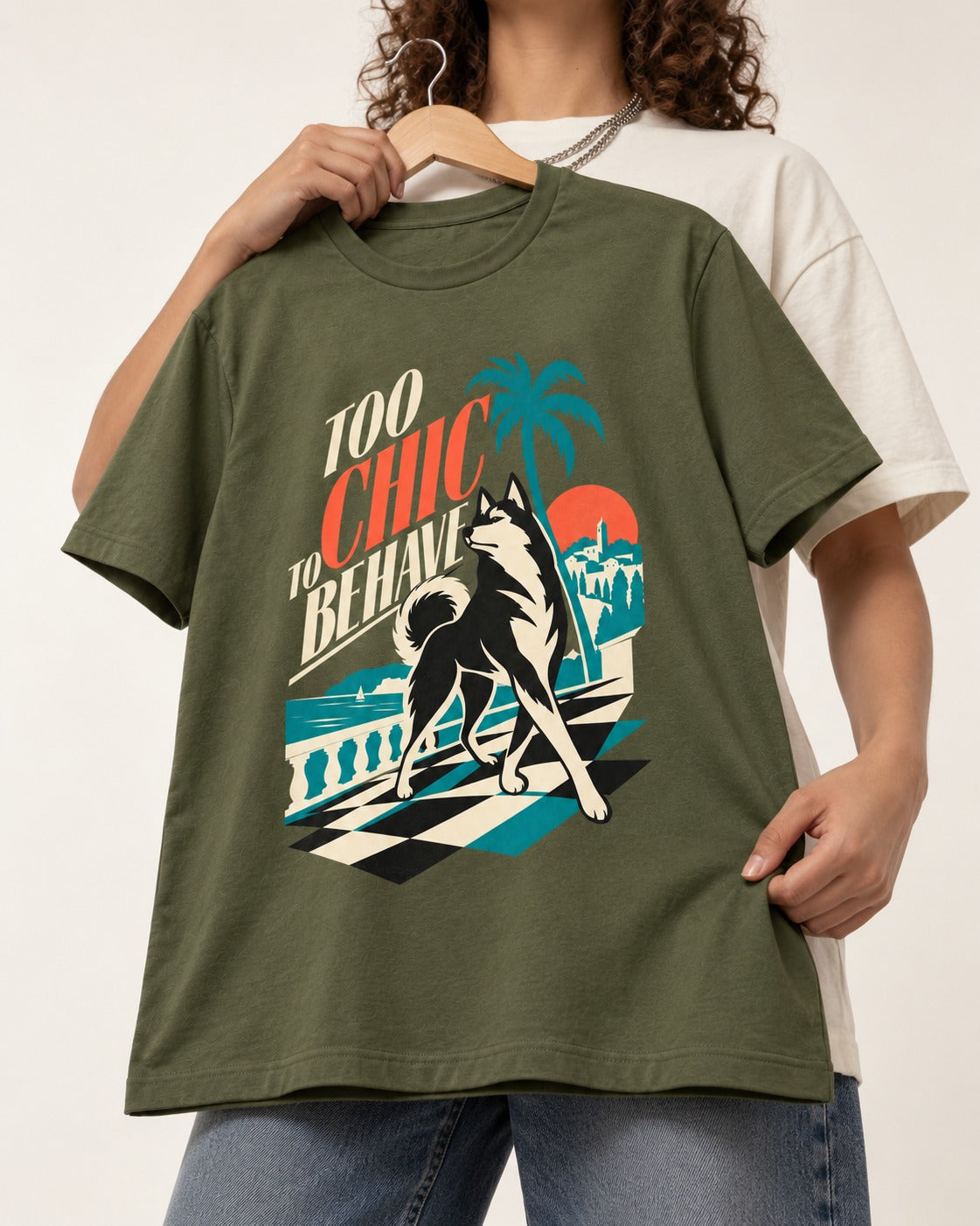 Husky Too Chic to Behave Riviera Graphic T-Shirt in Heather Military Green, held up on a hanger
