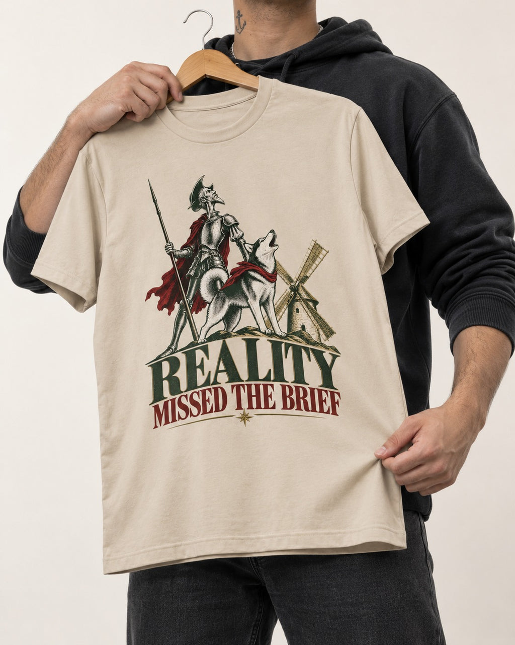 Reality Missed the Husky Brief T-Shirt in Sand, held up on a hanger