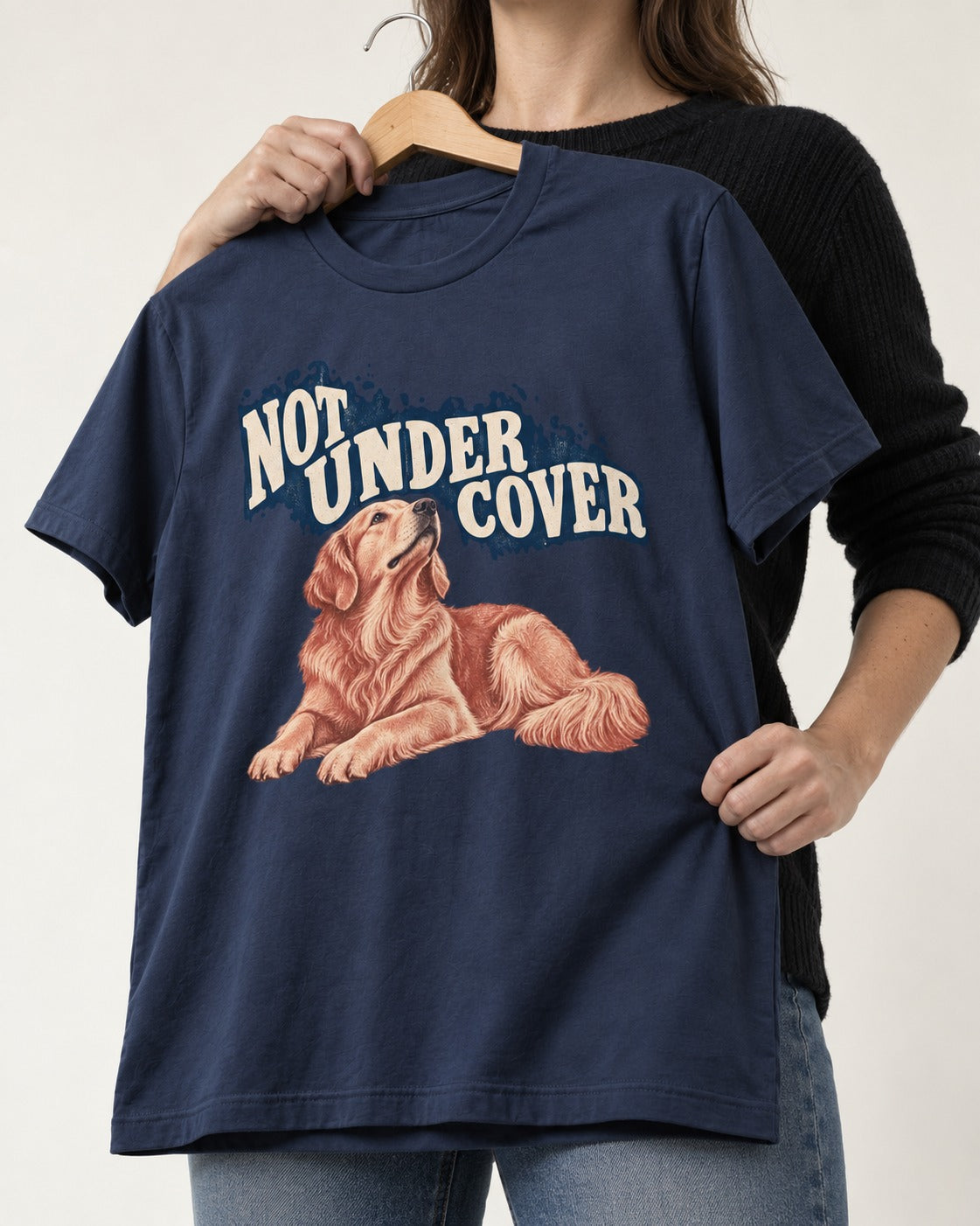 Not Under Cover Reclining Golden Retriever Graphic T-Shirt in Navy, held up on a hanger