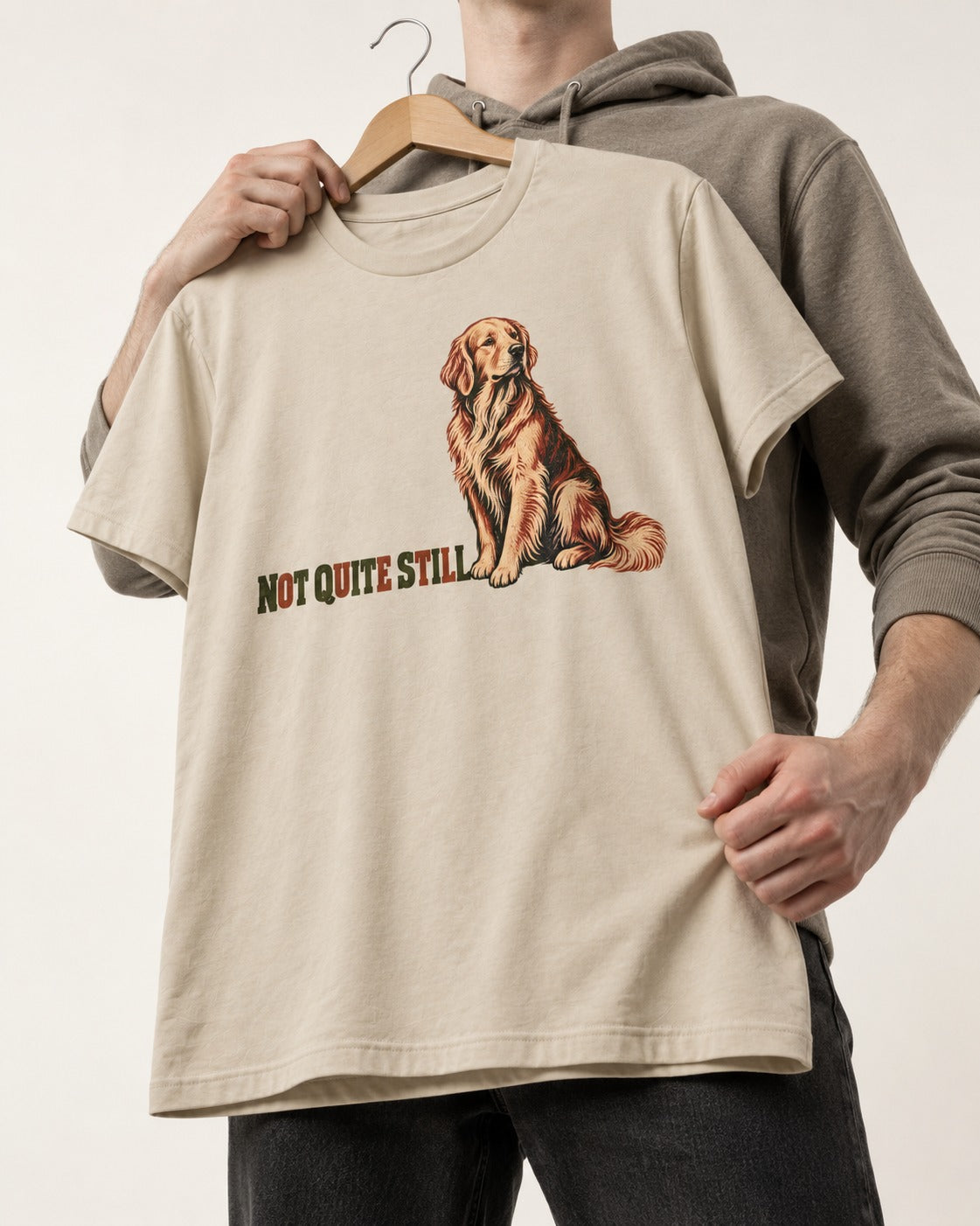 Golden Retriever Not Quite Still T-Shirt in Sand, held up on a hanger