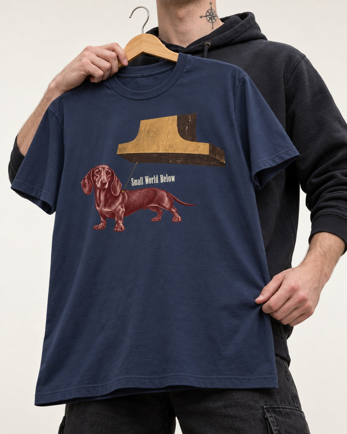 Dachshund Small World Below Giant Shoe Graphic T-Shirt in Navy, held up on a hanger