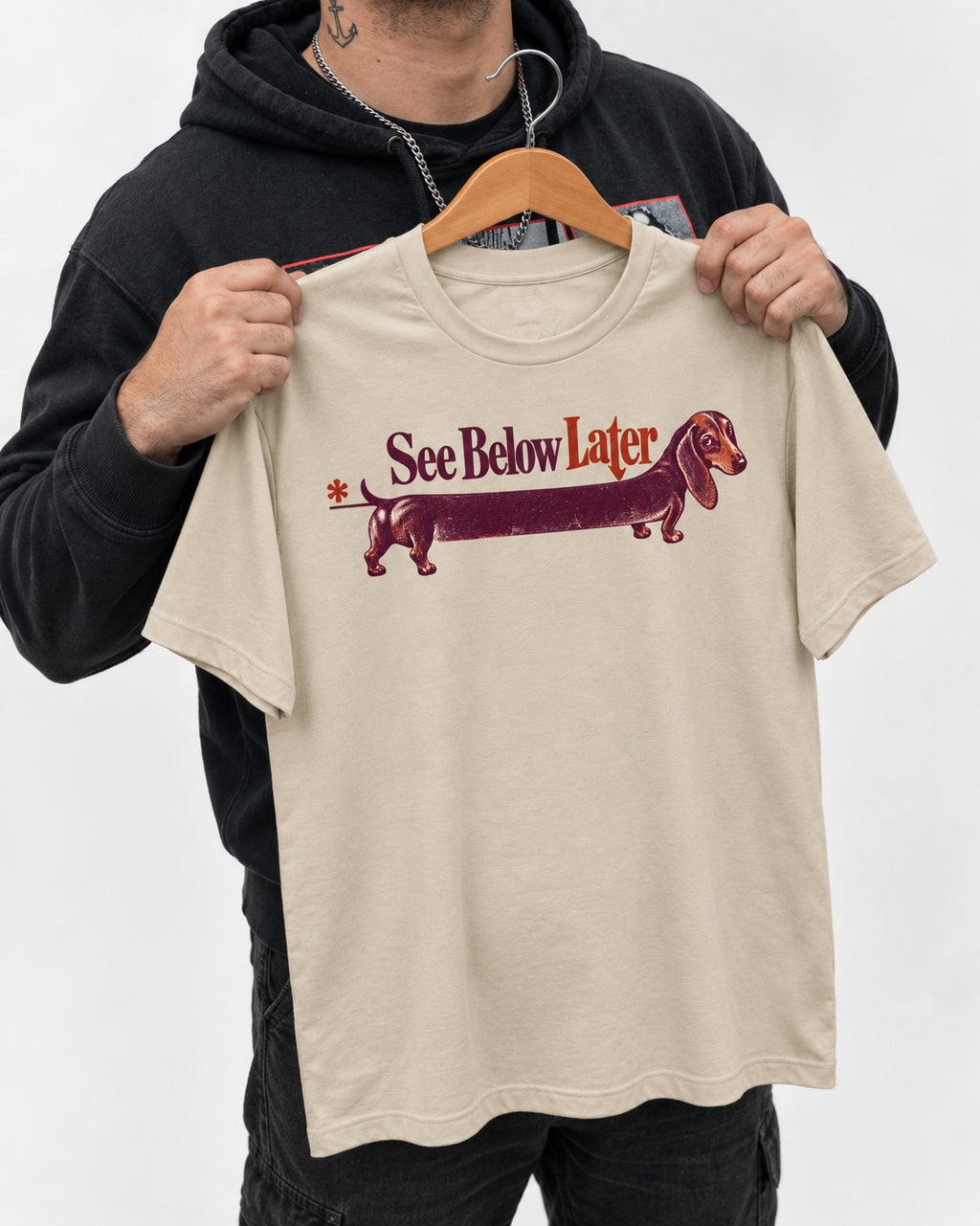 See Below Later Dachshund T-Shirt in Sand, held up on a hanger
