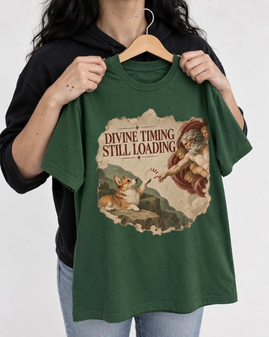 Corgi Divine Timing Still Loading Creation Parody T-Shirt in Forest Green, held up on a hanger