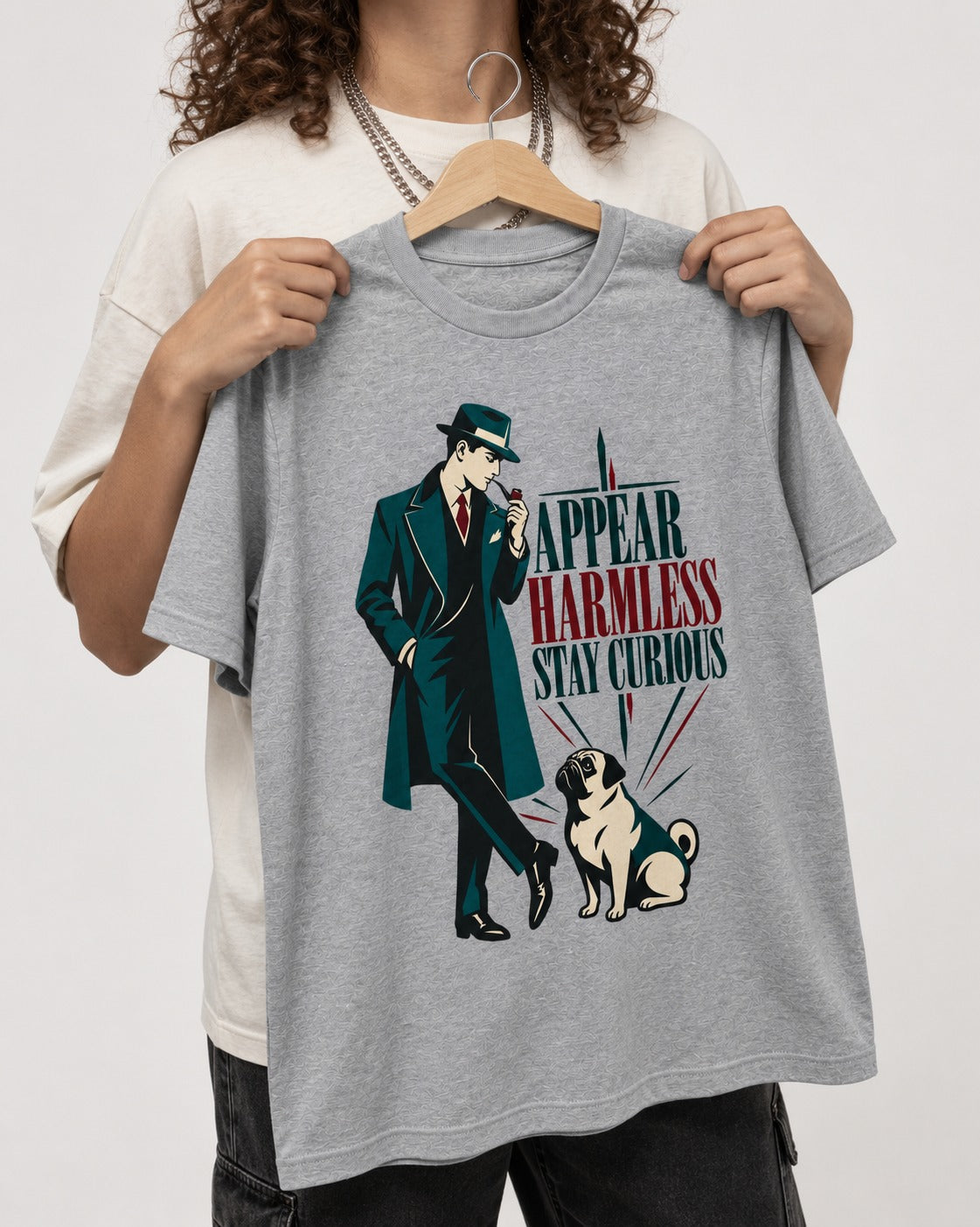 Pug Appear Harmless Stay Curious T-Shirt in Sport Grey, held up on a hanger