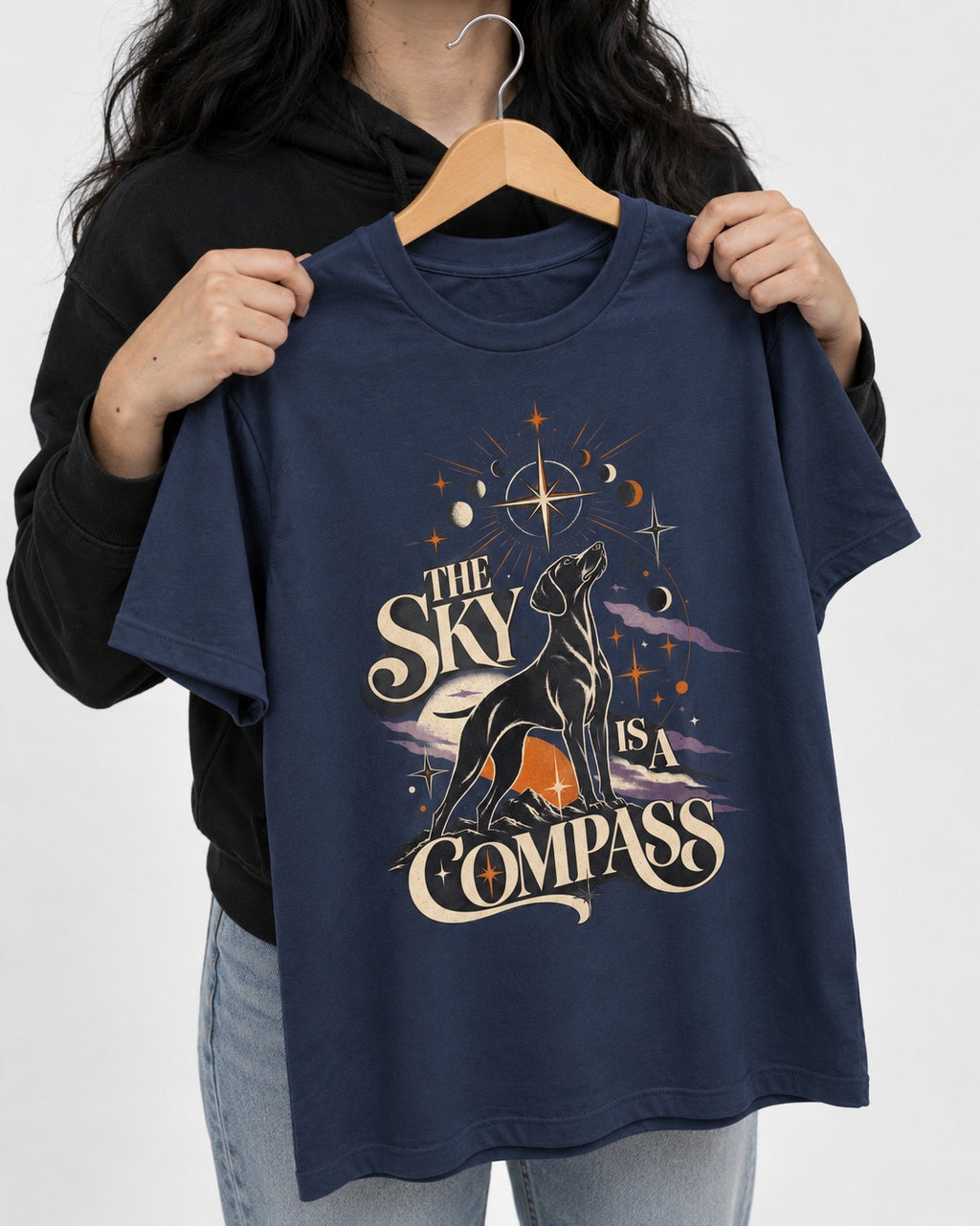 The Sky Is a Compass Celestial German Shorthaired Pointer Graphic T-Shirt in Navy, held up on a hanger