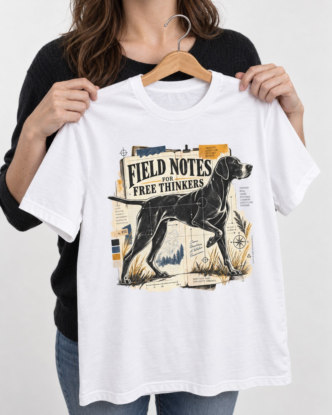 Field Notes for Free Thinkers Collage German Shorthaired Pointer Graphic T-Shirt in White, held up on a hanger