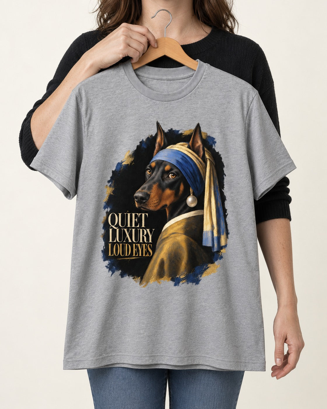 Doberman Quiet Luxury Loud Eyes Pearl Portrait Graphic T-Shirt in Sport Grey, held up on a hanger