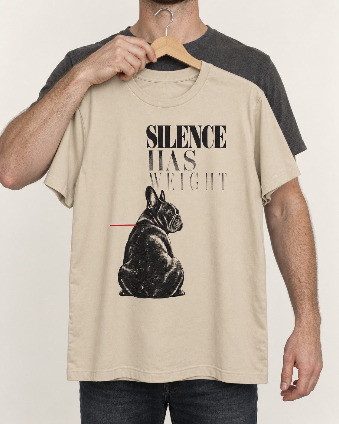 Silence Has Weight Frenchie T-Shirt in Sand, held up on a hanger