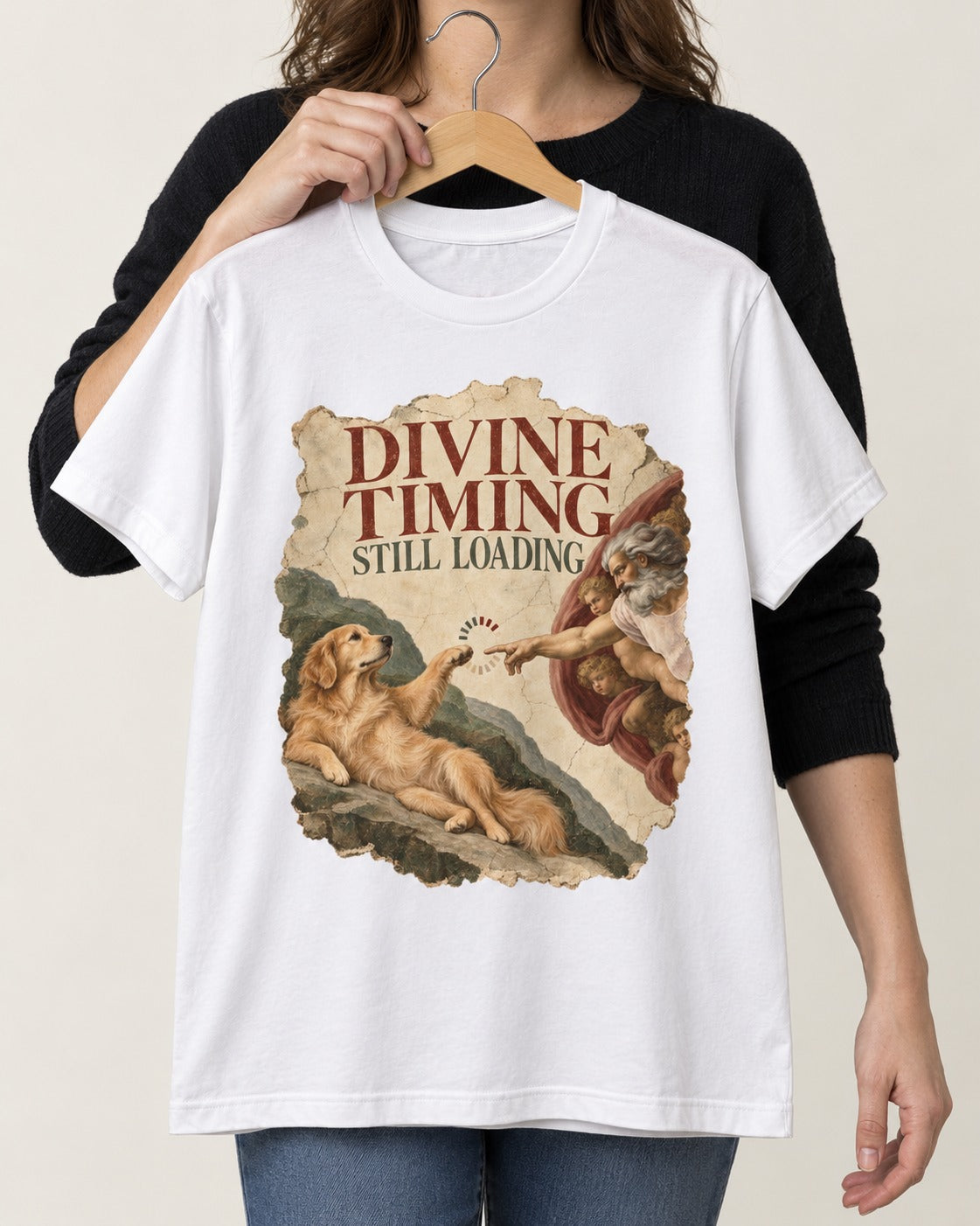 Divine Timing Still Loading Creation Scene Golden Retriever Graphic T-Shirt in White, held up on a hanger