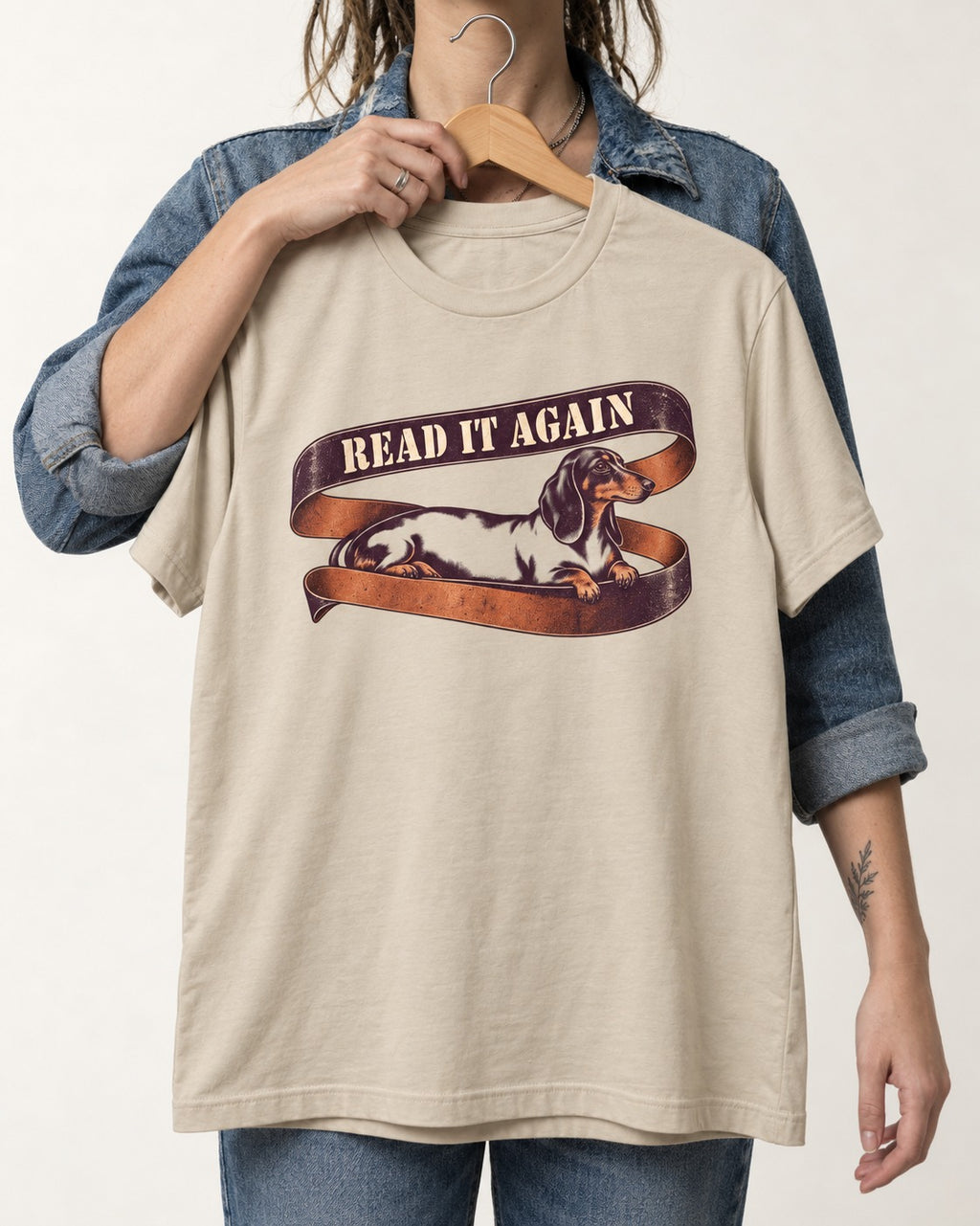 Read It Again Dachshund T-Shirt in Sand, held up on a hanger