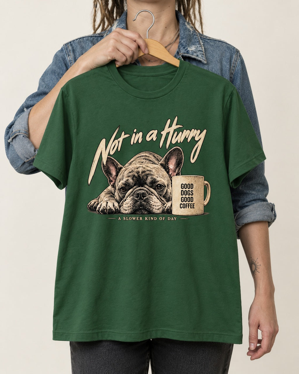 Frenchie Not in a Hurry Coffee Graphic T-Shirt in Forest Green, held up on a hanger