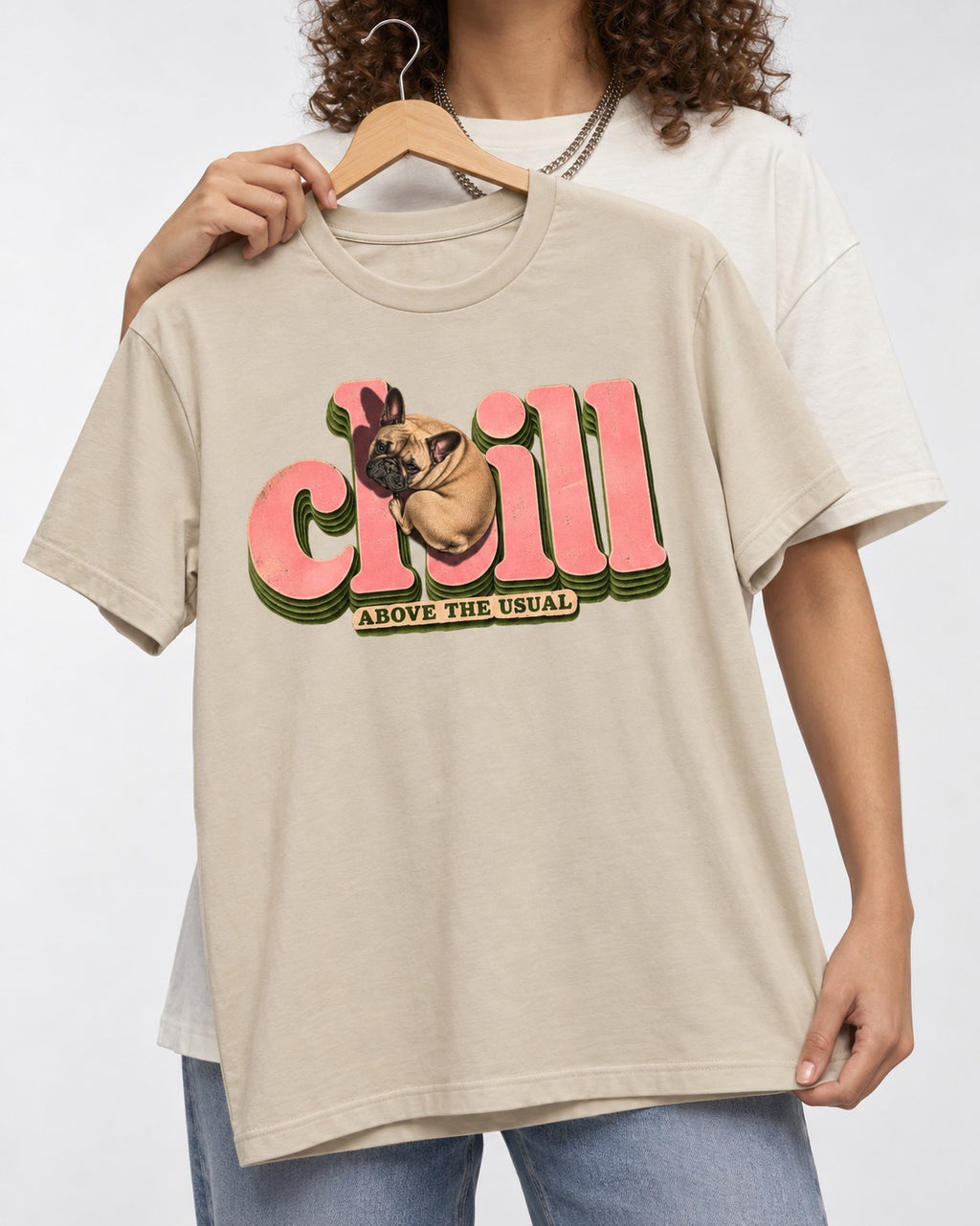 Frenchie Chill T-Shirt in Sand, held up on a hanger