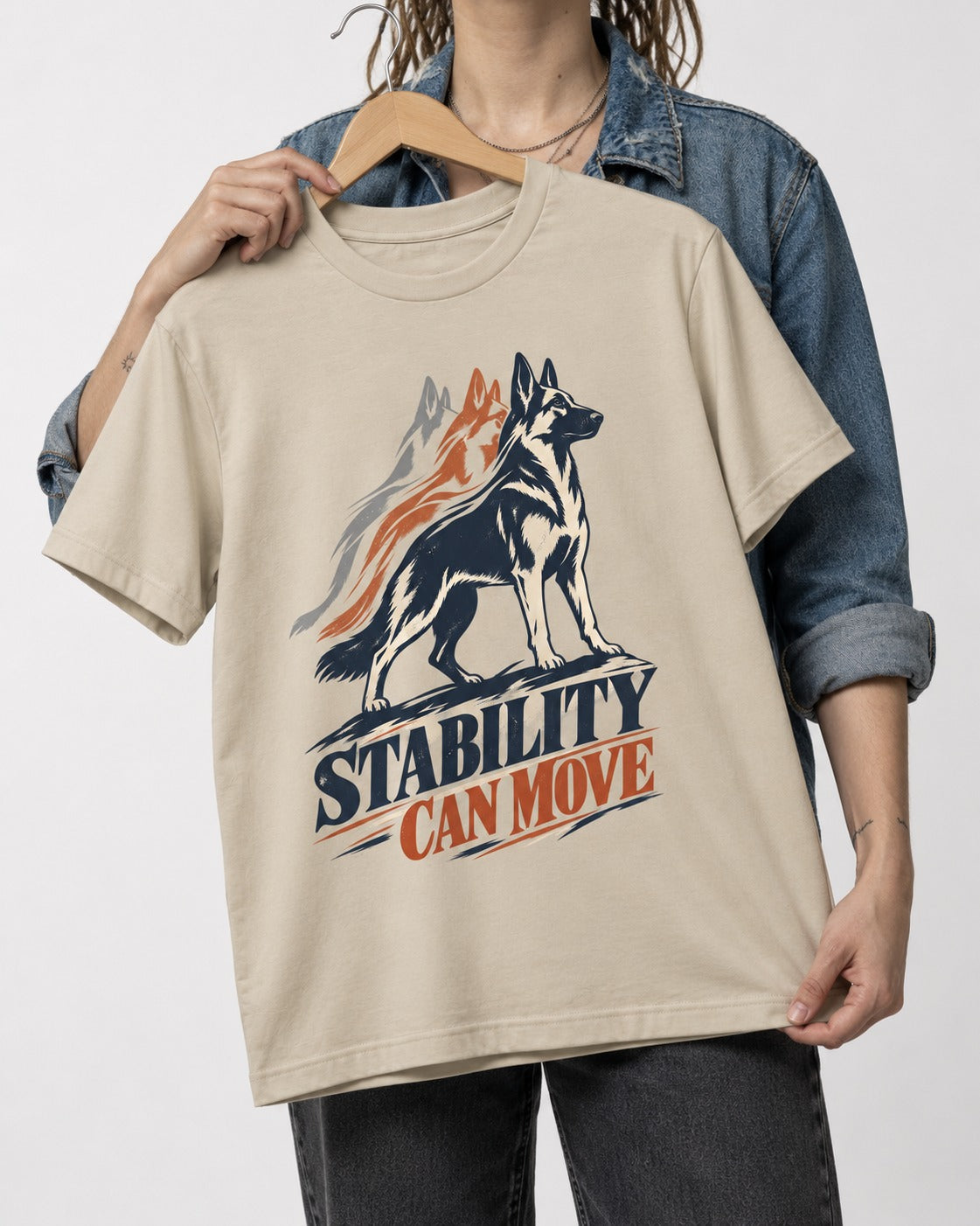 Stability Can Move German Shepherd Dog T-Shirt in Sand, held up on a hanger