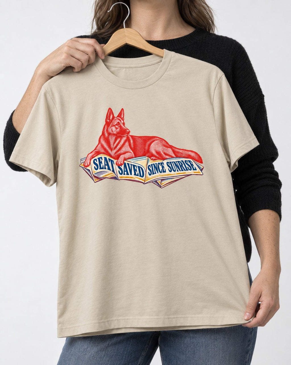 Seat Saved Since Sunrise German Shepherd Dog T-Shirt in Sand, held up on a hanger