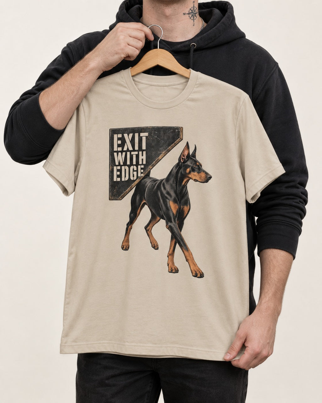 Exit with Doberman Edge T-Shirt in Sand, held up on a hanger