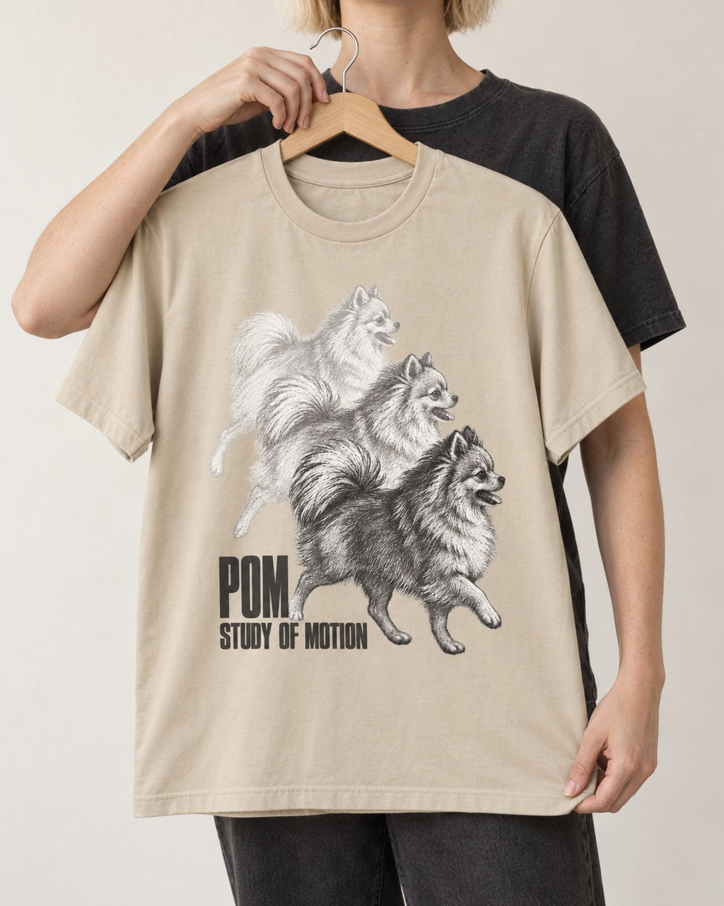 Pomeranian Study of Motion T-Shirt in Sand, held up on a hanger