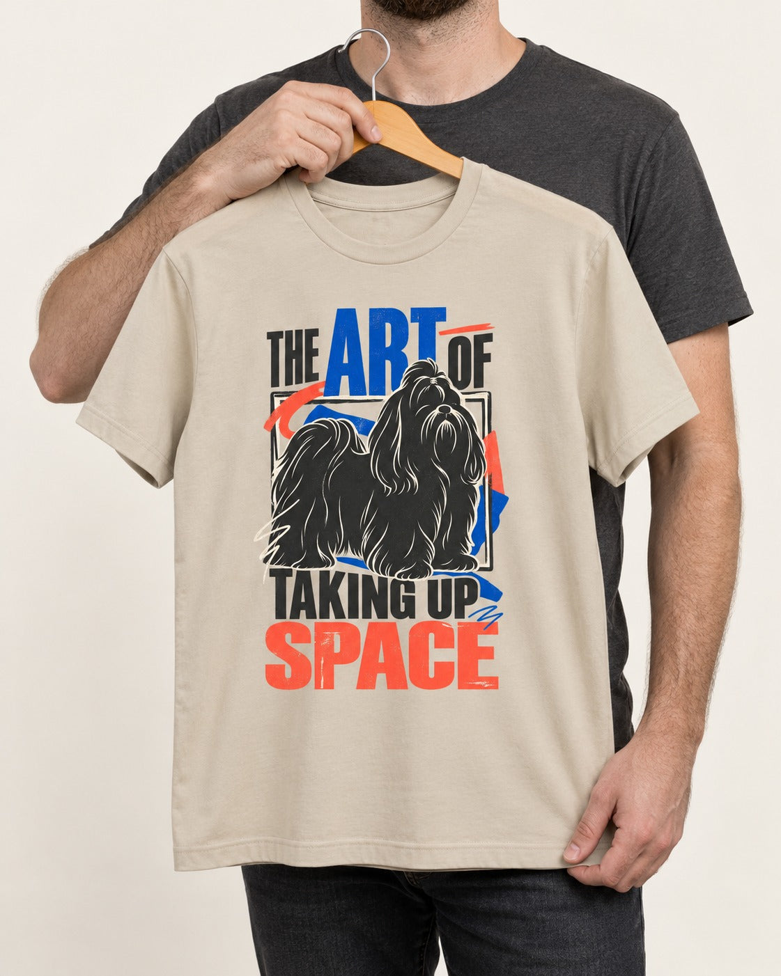 Shih Tzu Taking Up Space T-Shirt in Sand, held up on a hanger