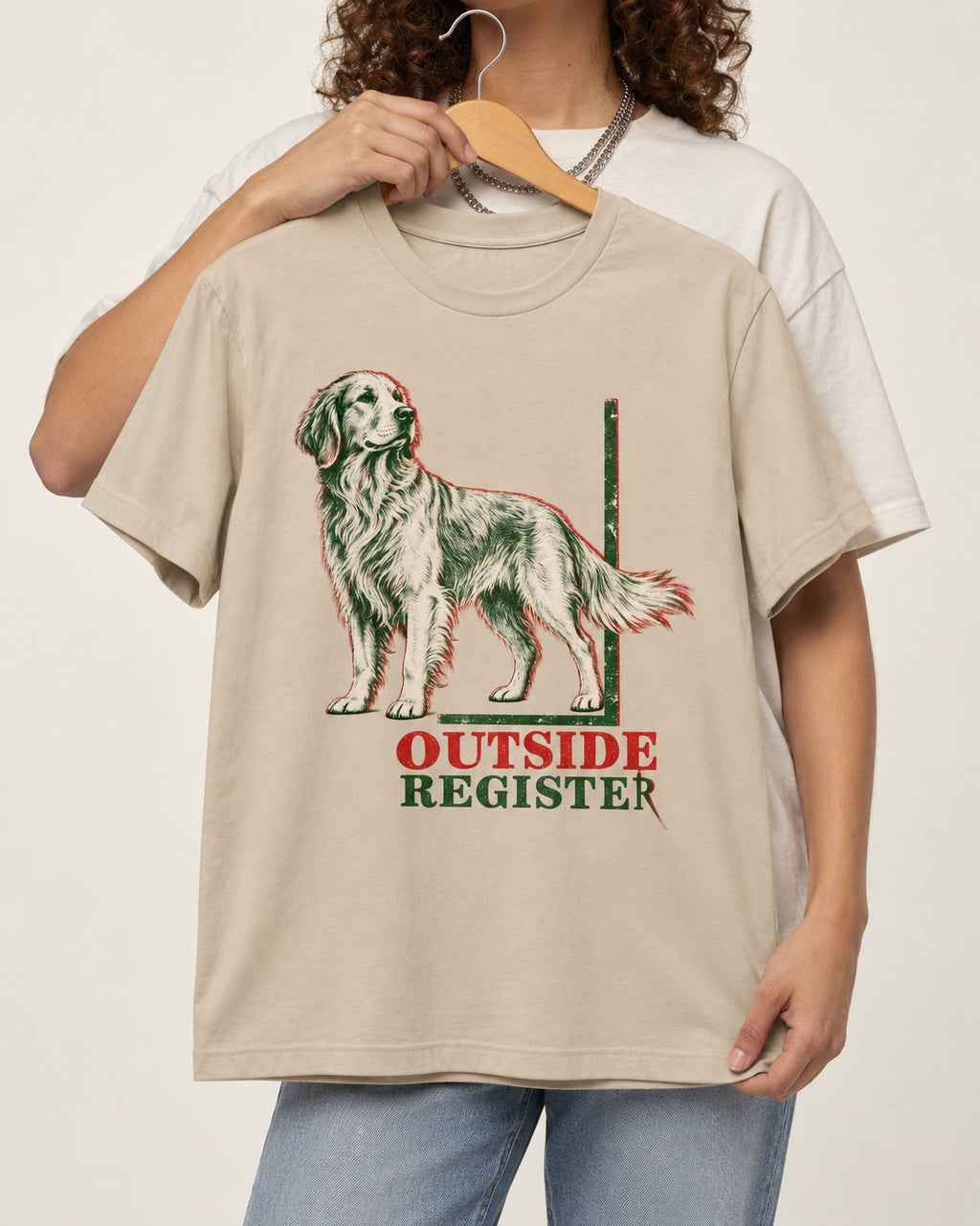 Outside Register Golden Retriever T-Shirt in Sand, held up on a hanger