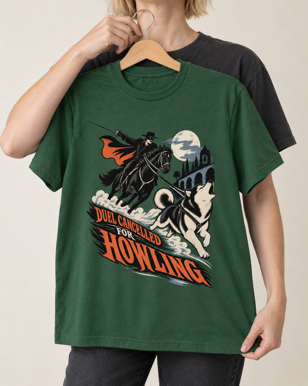 Husky Duel Cancelled for Howling Masked Rider Graphic T-Shirt in Forest Green, held up on a hanger