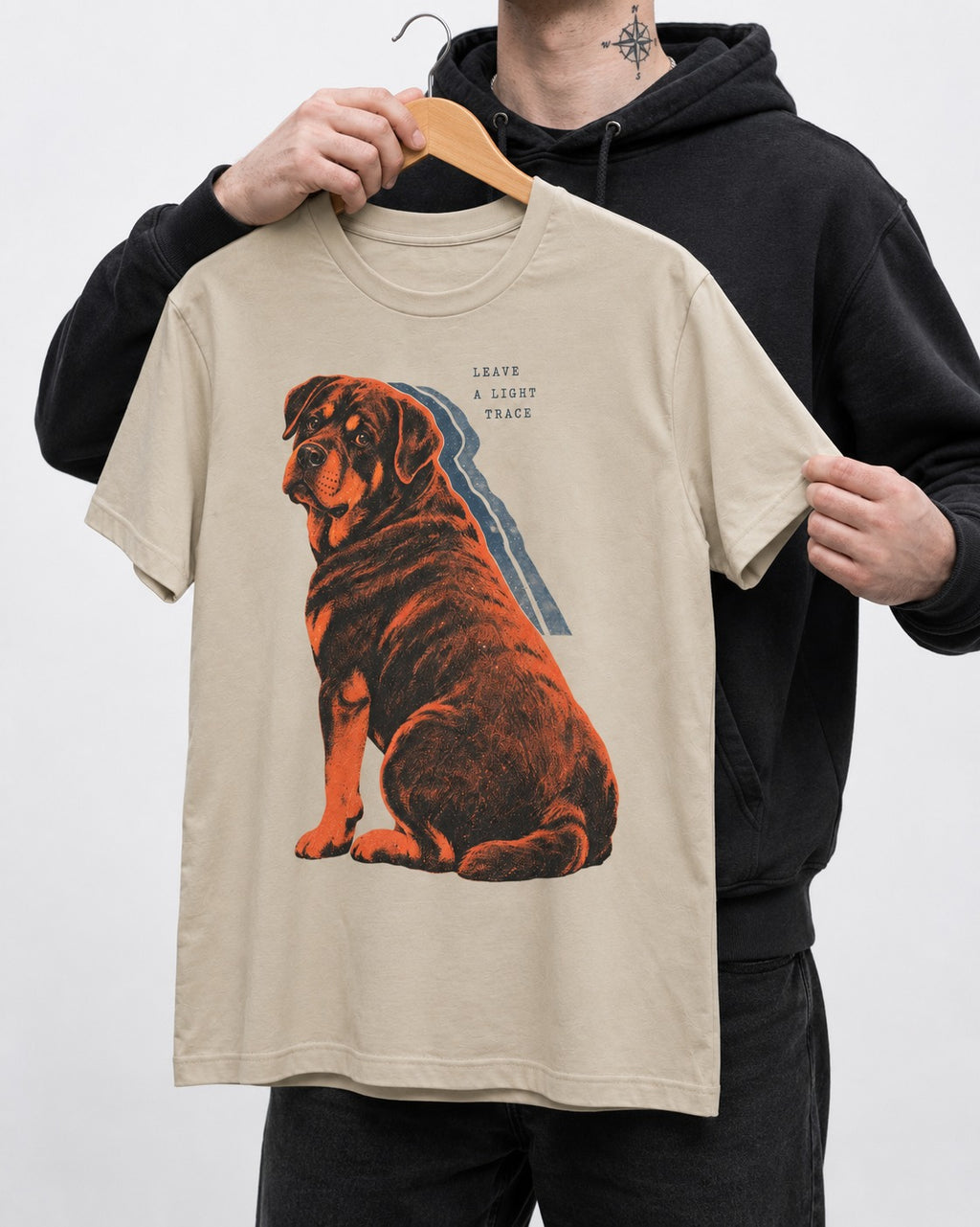 Rottweiler Leave a Light Trace T-Shirt in Sand, held up on a hanger