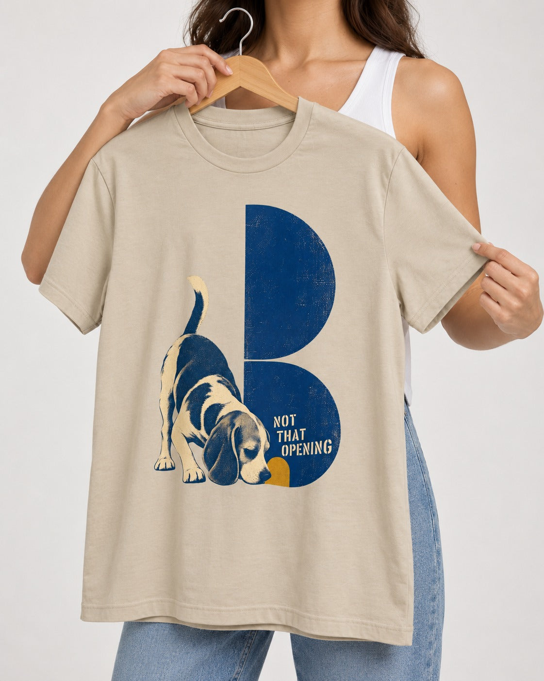Not That Opening Beagle T-Shirt in Sand, held up on a hanger