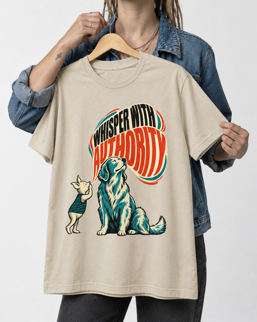 Golden Retriever Whisper with Authority T-Shirt in Sand, held up on a hanger