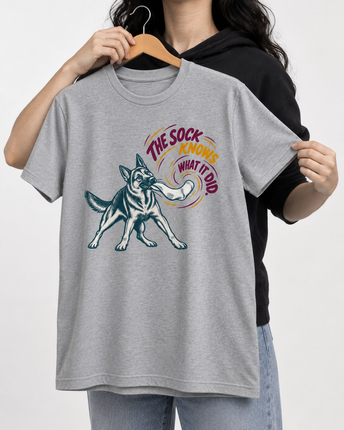 German Shepherd Dog The Sock Knows What I Did Graphic T-Shirt in Sport Grey, held up on a hanger