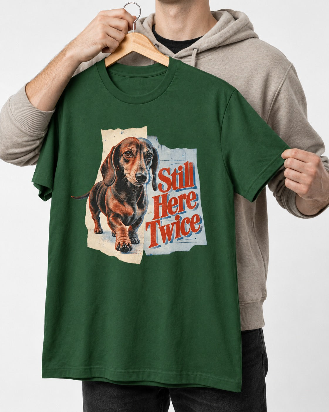 Dachshund Still Here Twice Torn Paper Graphic T-Shirt in Forest Green, held up on a hanger