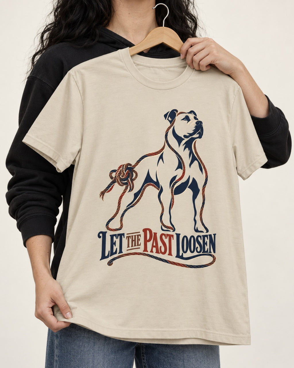 Pitbull Let the Past Loosen T-Shirt in Sand, held up on a hanger