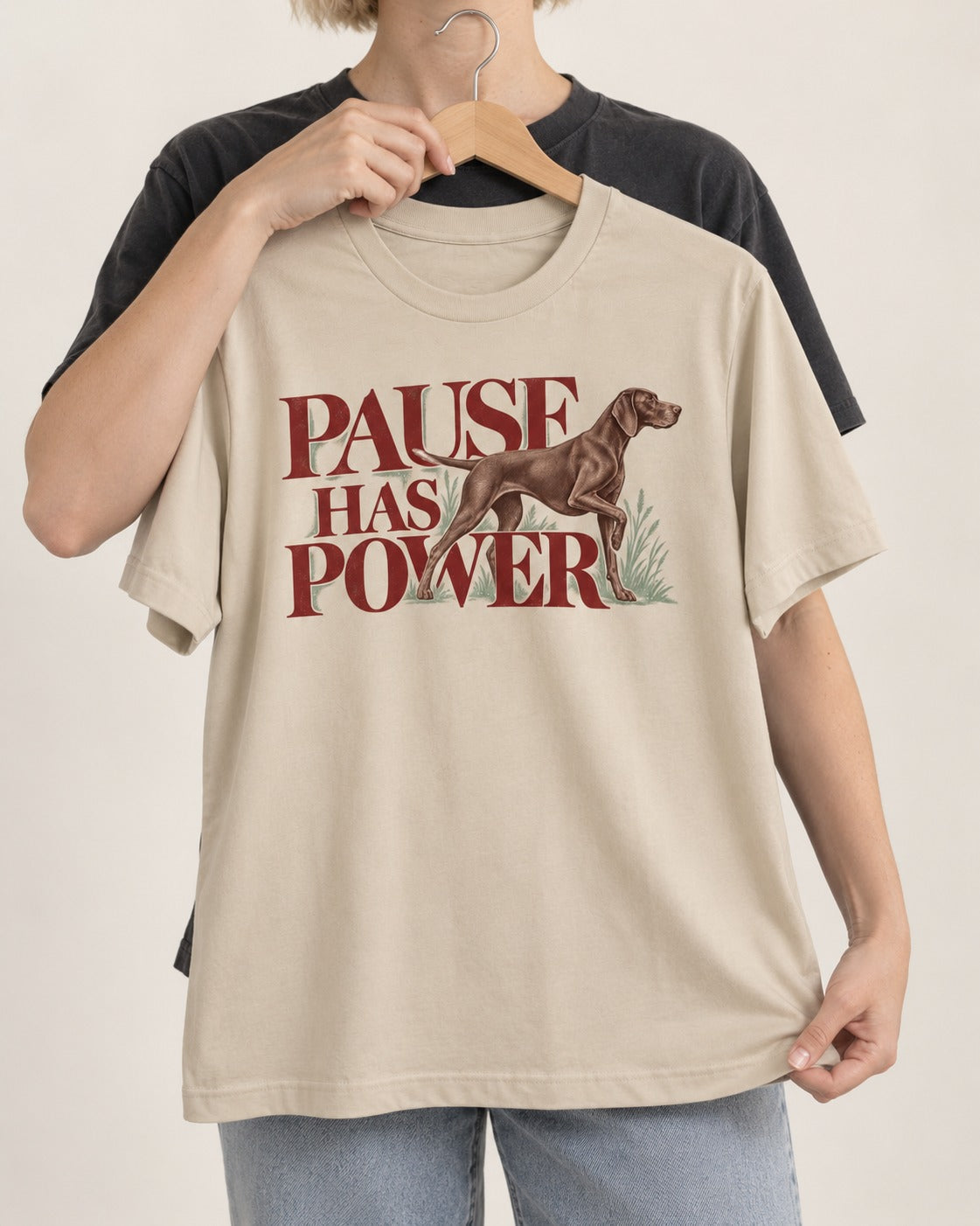 Pause Has Power German Shorthaired Pointer T-Shirt in Sand, held up on a hanger